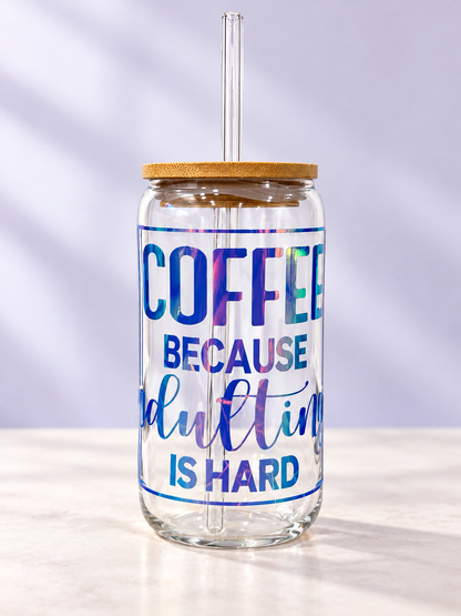 16oz clear glass coffee tumbler featuring holographic Coffee Because Adulting Is Hard lettering with bamboo lid and reusable glass straw.