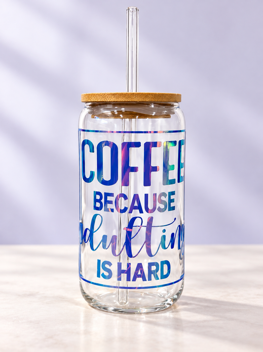 16oz clear glass coffee tumbler featuring holographic Coffee Because Adulting Is Hard lettering with bamboo lid and reusable glass straw.