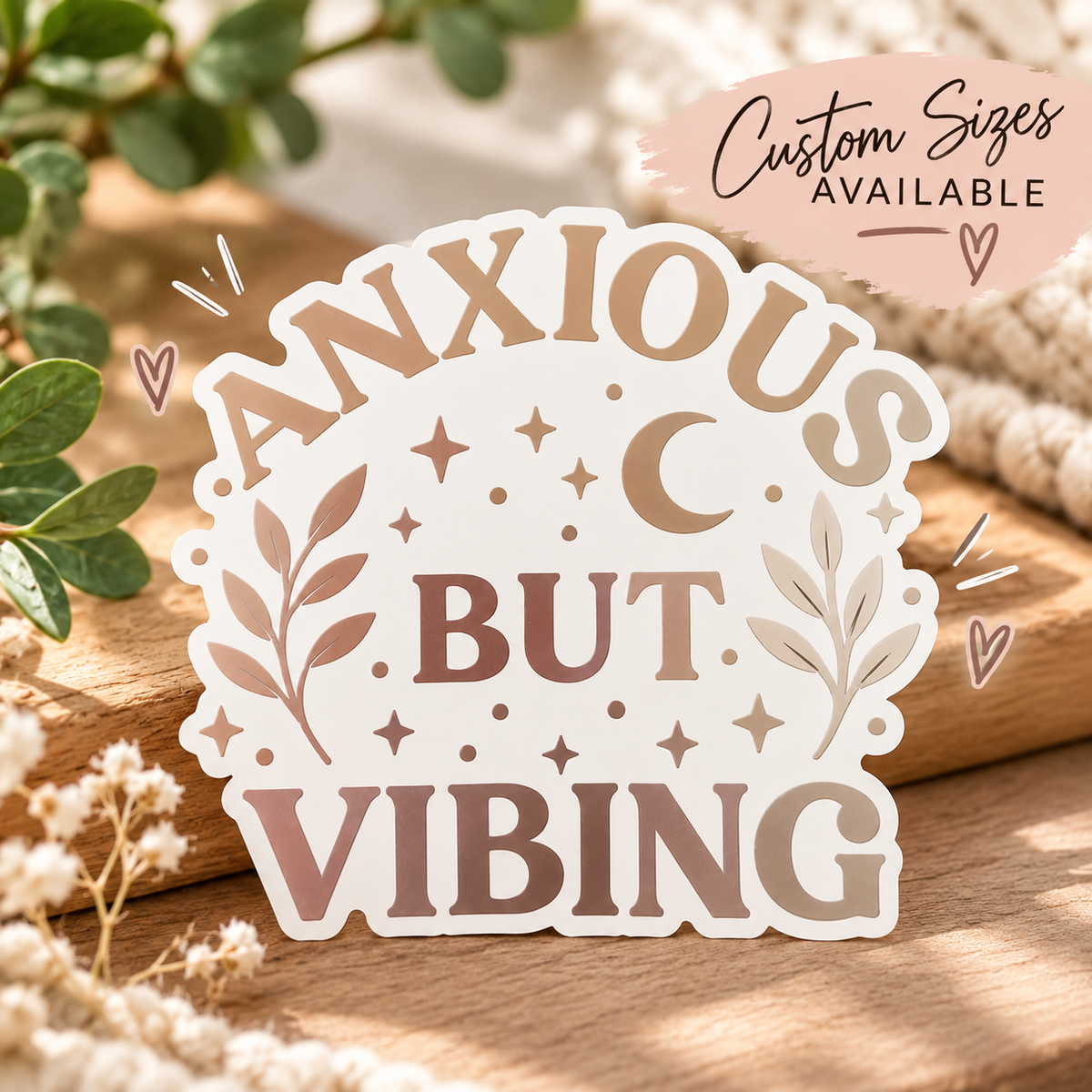 Anxious But Vibing vinyl decal with metallic lettering, a crescent moon, stars, and leafy branches on a neutral background.