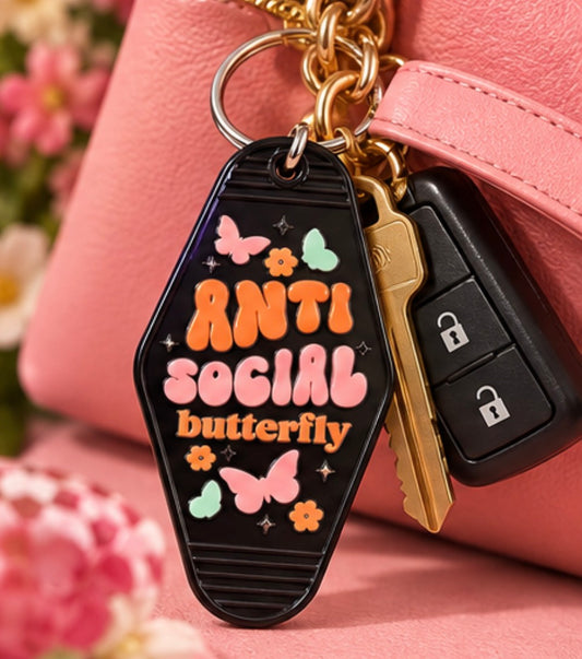 Black Anti Social Butterfly double-sided motel keychain with pink orange and mint butterfly and flower details