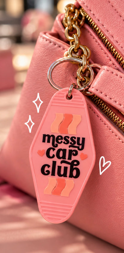 Pink double-sided Messy Car Club keychain with black lettering, heart details, and metal key ring